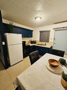 a kitchen with a table and a white refrigerator at Pedro's Place Peaceful 1 bedrm, 1 bathrm Villa in Sinajana