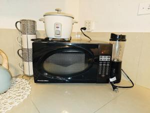a microwave sitting on a counter with a pot on top at Pedro's Place Peaceful 1 bedrm, 1 bathrm Villa in Sinajana