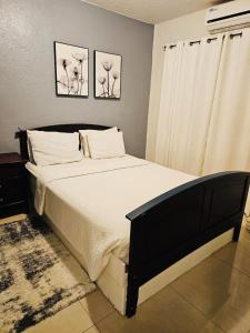a bed in a bedroom with two pictures on the wall at Pedro's Place Peaceful 1 bedrm, 1 bathrm Villa in Sinajana