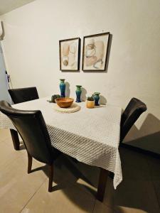 a dining room table with a white table cloth and chairs at Pedro's Place Peaceful 1 bedrm, 1 bathrm Villa in Sinajana +3 photos