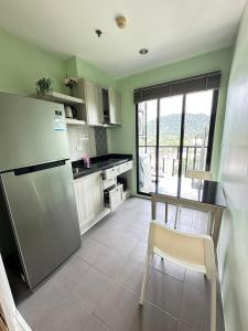 cocina con nevera y mesa con silla en The Base Height, en Ban Nong Chaeng