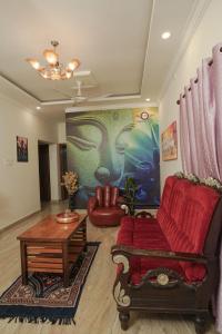 a living room with a red couch and a table at SM Stay Inn in Mangalore