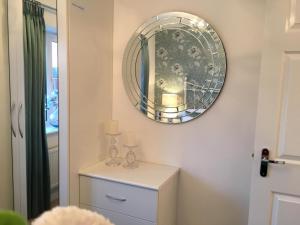 a mirror on a wall above a dresser in a room at Premier stays in Warrington