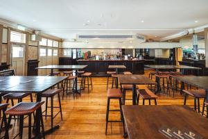 シドニーにあるRiverview Hotel Tempeのテーブルと椅子とバーのあるレストラン