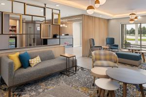 a living room with a couch and tables and chairs at TownePlace Suites by Marriott Mankato in Mankato