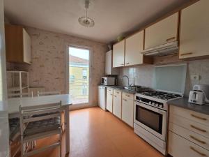 a kitchen with white appliances and a large window at Appartement Tout Confort entre Plage et Commerces à Saint-Brevin-les-Pins - FR-1-364-55 in Saint-Brevin-les-Pins