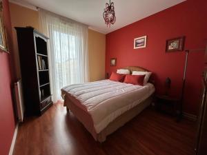 a bedroom with red walls and a bed with red pillows at Appartement Tout Confort entre Plage et Commerces à Saint-Brevin-les-Pins - FR-1-364-55 in Saint-Brevin-les-Pins