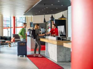 a group of people standing at a counter at ibis Wien Hauptbahnhof in Vienna