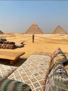 una habitación con sofás y pirámides en el desierto en Pyramids Legend View Hotel, en El Cairo