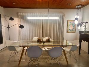 a dining room with a glass table and chairs at Chic Designer Family Rooms in Shared Bungalow near LRT SS1 PJ in Petaling Jaya +26 photos
