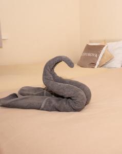a gray towel is sitting on a bed at Quiet Yellow Rest House Sleeps 7 in Swindon