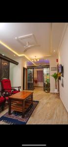 a living room with a wooden table and a couch at SM Stay Inn in Mangalore