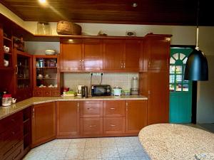 a kitchen with wooden cabinets and a microwave at Chic Designer Family Suite in Shared Bungalow near LRT SS1 PJ in Petaling Jaya