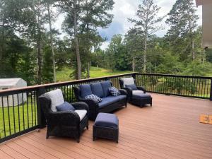 a deck with chairs and couches on a balcony at Experience Serenity with Family and Friends in Macon