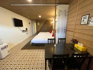 a hotel room with a bed and a table and chairs at 九份迦南民宿 in Jiufen