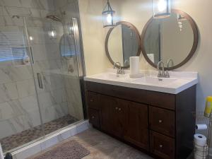 a bathroom with a sink and a shower with mirrors at Experience Serenity with Family and Friends in Macon