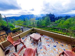 a balcony with chairs and a table and a view at Awinco Rest Inn in Haputale