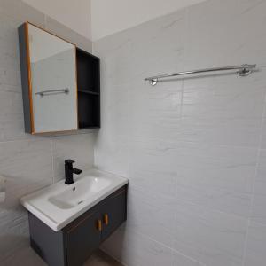 un baño con lavabo y espejo en Seashell Family-555普吉岛木屋走几步到邦涛海滩看日落周边餐饮方便, en Bang Tao Beach