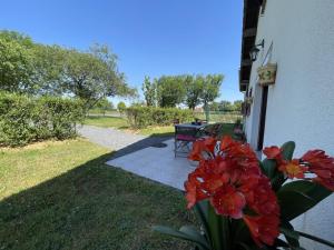 a patio with a table and flowers in the grass at Gîte Le Mailloux : Nature, Confort et Randonnée - FR-1-489-461 in Saligny-sur-Roudon +14 photos