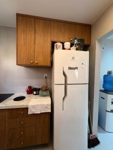 een keuken met een witte koelkast en houten kasten bij Apartment - Metropolitan Region of Belém in Ananindeua