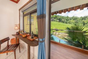 Pu LuongPu Luong EcoLuxe Resort & Spa的一间有桌子和窗户的房间，可以欣赏风景 更多16张照片