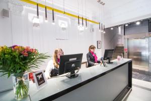 two women sitting at a reception desk with their computers at Petit Palace Arenal in Madrid