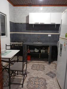 a kitchen with a table and a sink and a refrigerator at Morada Donatella in Posadas