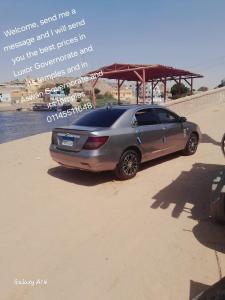 a poster of a car parked on the beach at اسوان in Naj‘ al ‘Amrāb