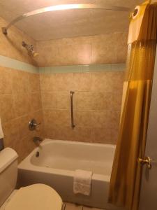 a bathroom with a tub and a toilet and a sink at Garden Inn and Extended Stay in Shepherdsville