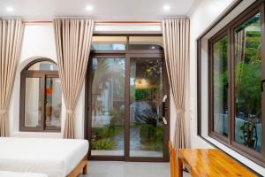 Un dormitorio con una cama y una ventana grande. en Lala Boutique Villas Ninh Binh, en Ninh Binh 38 fotos más
