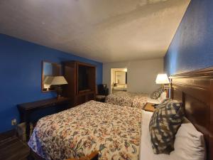 a hotel room with two beds and blue walls at Garden Inn and Extended Stay in Shepherdsville