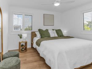 a white bedroom with a large bed and two windows at Wave Whisperer in Kingscliff