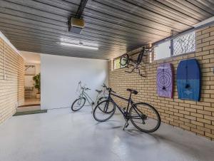 two bikes parked against a brick wall in a garage at Wave Whisperer in Kingscliff