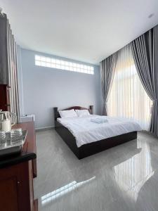 sypialnia z dużym łóżkiem i biurkiem w obiekcie BTB Homestay w mieście Phumĭ Kâmpóng Âmpĭl