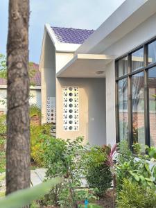 Biały dom z roślinami przed nim w obiekcie BTB Homestay w mieście Phumĭ Kâmpóng Âmpĭl