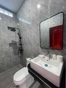 łazienka z umywalką, toaletą i lustrem w obiekcie BTB Homestay w mieście Phumĭ Kâmpóng Âmpĭl