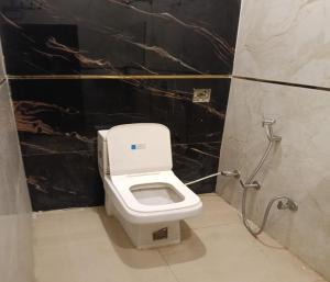 a bathroom with a white toilet in a stall at Hotel Kaushalya in Ayodhya