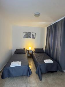a room with two beds in a room at Apart Boulevard in Vuelta del Paraguayo