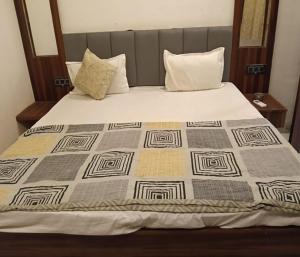 a bed with a quilt on top of it at Hotel Kaushalya in Ayodhya