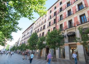 a group of people walking down a street in front of a building at Petit Palace Arenal in Madrid