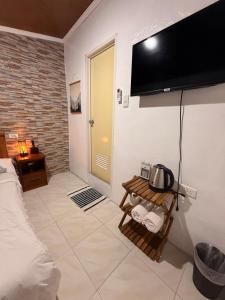 a bedroom with a tv on the wall and a bed at Sunny Terrace in Baler
