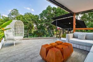 a patio with a couch and a chair and an umbrella at Deimena Cozy 3 BR Private Pool Villa ZN353 in Pererenan