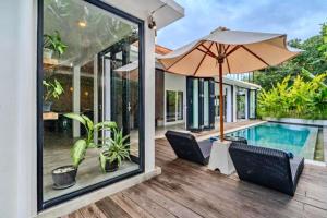 a house with a pool and a patio with chairs and an umbrella at Deimena Cozy 3 BR Private Pool Villa ZN353 in Pererenan