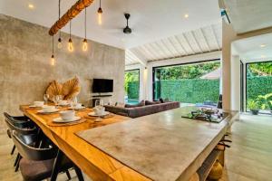 a large wooden table in a living room with a couch at Deimena Cozy 3 BR Private Pool Villa ZN353 in Pererenan