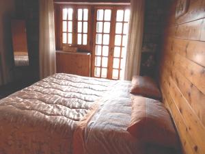 a bedroom with a bed with a wooden wall at La Casa di Walter in Palata