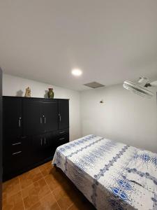 um quarto com uma cama e uma cómoda preta em Hostal Maxim em Puerto Isaacs