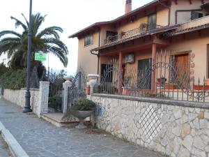 a building with a fence and a palm tree at La Casa di Walter in Palata