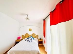 ein Schlafzimmer mit einem Bett und einem roten Vorhang in der Unterkunft MIMOSA Escapada ideal en Roses: casa espaciosa, jardín privado y terrazas al sol. - ES-258-170 in Montjoys + 15 Fotos
