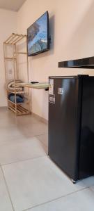 a kitchen with a black refrigerator and a table at Studio planejado em itaipava in Araras Petropolis