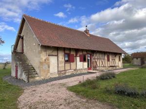 an old building with a brown roof and red doors at Gîte chaleureux à Chapeau avec jardin et terrasse - FR-1-489-601 in Chapeau